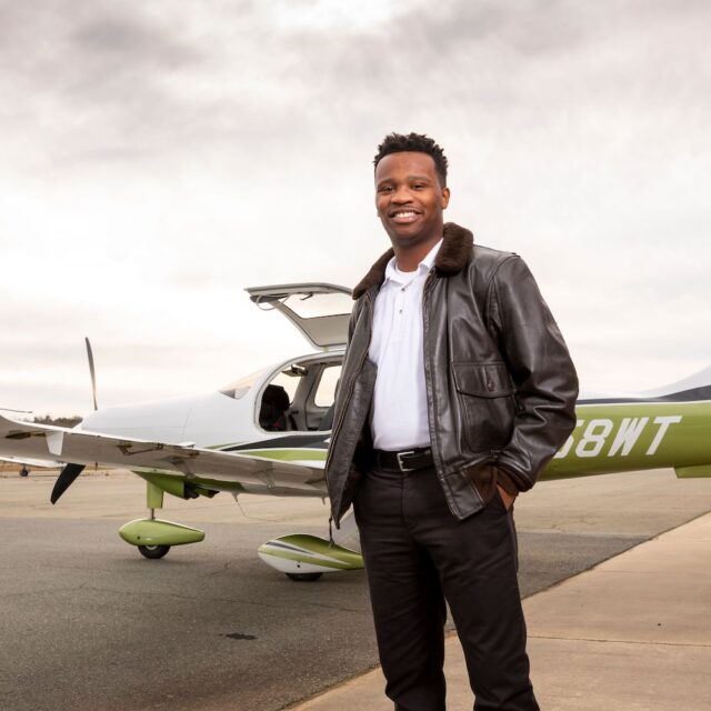 Fly For The Culture founder Courtland Savage standing in front of an airplane.